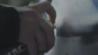 Street artist drawing graffiti on a wall. Close-up of a hand with a spray can. White paint is spreading on the wall. Street art. Creativity. 4K