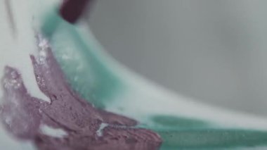 Close-up of a brush painting with dark red paint. An artist draws on a mask. Drawing with paint and spray can. Dark red and green. Art. Creativity. 4K