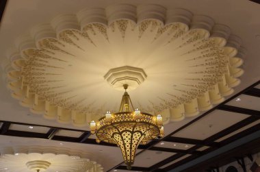 beautiful gold design chandlier on the gold color ceiling 