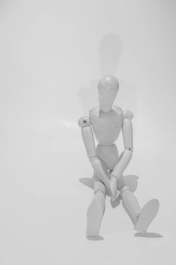 sad wooden mannequin on a black background