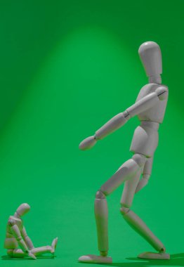 wooden mannequin scolding another smaller mannequin. green screen
