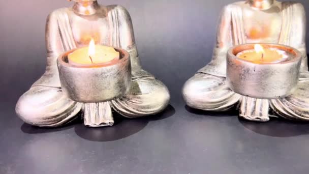 Two Buddhas Burning Candles Black Background — Stockvideo