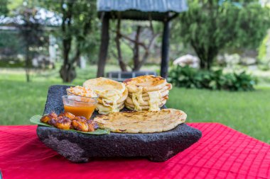 typical Salvadoran dish, cheese pupusas with cabbage and tomato sauce. rice and corn pupusas stuffed with cheese, beans or other ingredients