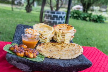 typical Salvadoran dish, cheese pupusas with cabbage and tomato sauce. rice and corn pupusas stuffed with cheese, beans or other ingredients