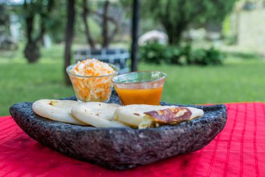 typical Salvadoran dish, cheese pupusas with cabbage and tomato sauce. rice and corn pupusas stuffed with cheese, beans or other ingredients