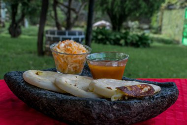 typical Salvadoran dish, cheese pupusas with cabbage and tomato sauce. rice and corn pupusas stuffed with cheese, beans or other ingredients