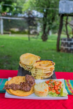 typical Salvadoran dish, cheese pupusas with cabbage and tomato sauce. rice and corn pupusas stuffed with cheese, beans or other ingredients