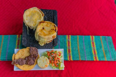 typical Salvadoran dish, cheese pupusas with cabbage and tomato sauce. rice and corn pupusas stuffed with cheese, beans or other ingredients