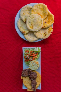 typical Salvadoran dish, cheese pupusas with cabbage and tomato sauce. rice and corn pupusas stuffed with cheese, beans or other ingredients