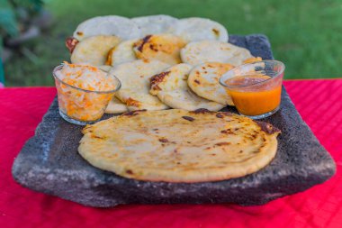 typical Salvadoran dish, cheese pupusas with cabbage and tomato sauce. rice and corn pupusas stuffed with cheese, beans or other ingredients
