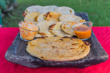 typical Salvadoran dish, cheese pupusas with cabbage and tomato sauce. rice and corn pupusas stuffed with cheese, beans or other ingredients