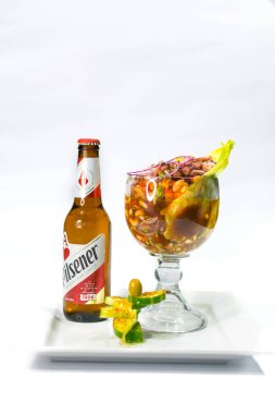 Shrimp cocktail accompanied by a traditional Salvadoran Pilsener beer