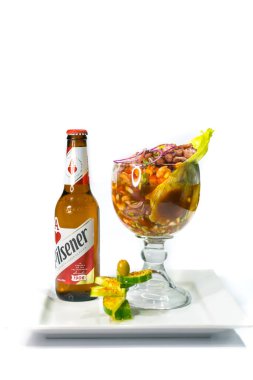Shrimp cocktail accompanied by a traditional Salvadoran Pilsener beer
