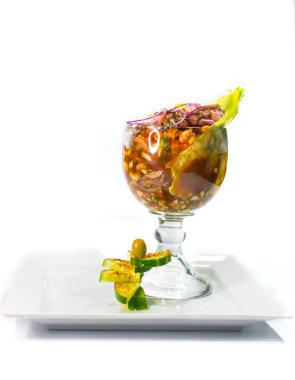 shrimp cocktail garnished with cucumbers black background white plate