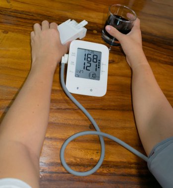female smoker and drinker, measuring blood pressure and heart rate. high blood pressure and heart rate