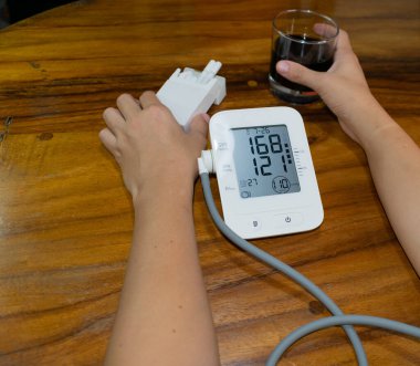 female smoker and drinker, measuring blood pressure and heart rate. high blood pressure and heart rate