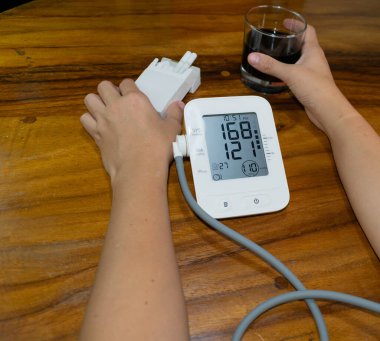 female smoker and drinker, measuring blood pressure and heart rate. high blood pressure and heart rate