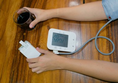 female smoker and drinker, measuring blood pressure and heart rate. high blood pressure and heart rate