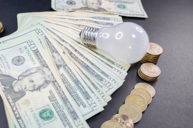 dollar bills and coins with a spotlight. expensive energy