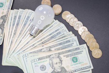 dollar bills and coins with a spotlight. expensive energy