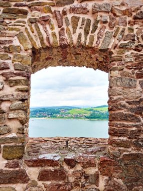 Czorsztyn 'deki harabe şato bulutlu bir günde Karpatlar' ın dağlarındaki gölün yanında yer alıyor. Ağustos 2022 Yaz