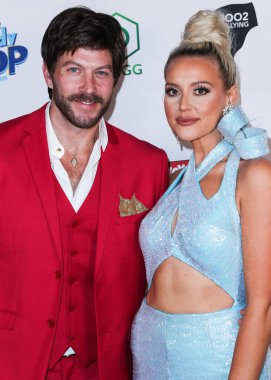 Johnny Wujek ve şarkıcı Katie Welch, 8 Aralık 2021 'de SİKIO, DOGG madeni paraları, Şeker Pop ve Kurabiye Pop ve Tito' nun Votkası tarafından sunulan 8.