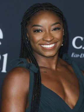 Jimnastikçi Simone Biles Aliette elbisesi, Christian Louboutin ayakkabısı ve Judith Leiber çantası taşırken Matteo mücevheri giyerek 15 Kasım 2021 'de Los Angeles, Kaliforniya' daki Getty Center 'da düzenlenen 6.