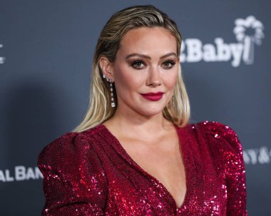 Aktris Hilary Duff, ayakkabı giyerken ve Jimmy Choo 'nun el çantası taşırken Osman elbisesi ve Rahamoniv mücevheri takıyor. 13 Kasım 2021' de ABD 'nin Los Angeles kentindeki Pasifik Tasarım Merkezi' nde düzenlenen 10 yıllık Bebek Galası 2021 'e geliyor..