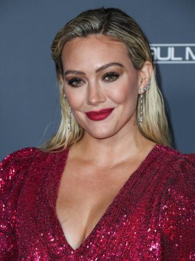 Aktris Hilary Duff, ayakkabı giyerken ve Jimmy Choo 'nun el çantası taşırken Osman elbisesi ve Rahamoniv mücevheri takıyor. 13 Kasım 2021' de ABD 'nin Los Angeles kentindeki Pasifik Tasarım Merkezi' nde düzenlenen 10 yıllık Bebek Galası 2021 'e geliyor..