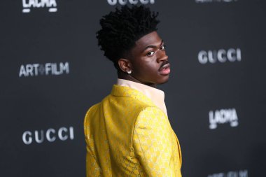 Rapper Lil Nas X wearing a suit by Gucci arrives at the 10th Annual LACMA Art + Film Gala 2021 held at the Los Angeles County Museum of Art on November 6, 2021 in Los Angeles, California, United States.  clipart