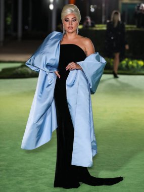 Şarkıcı Lady Gaga (Stefani Joanne Angelina Germanotta) özel bir Schiaparelli elbisesi ve Chopard mücevheri giyerek 25 Eylül 2021 'de Los Ang' daki Akademi Film Müzesi 'nin açılışındaki Akademi Müzesi' ne gelir.