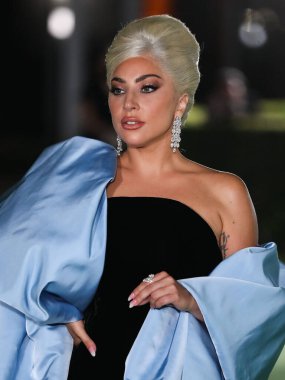 Şarkıcı Lady Gaga (Stefani Joanne Angelina Germanotta) özel bir Schiaparelli elbisesi ve Chopard mücevheri giyerek 25 Eylül 2021 'de Los Ang' daki Akademi Film Müzesi 'nin açılışındaki Akademi Müzesi' ne gelir.