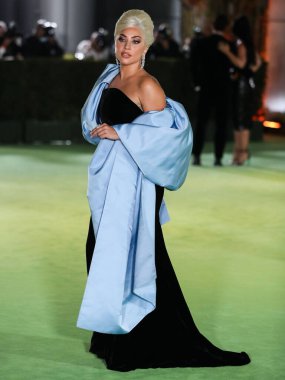 Şarkıcı Lady Gaga (Stefani Joanne Angelina Germanotta) özel bir Schiaparelli elbisesi ve Chopard mücevheri giyerek 25 Eylül 2021 'de Los Ang' daki Akademi Film Müzesi 'nin açılışındaki Akademi Müzesi' ne gelir.