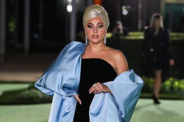 Şarkıcı Lady Gaga (Stefani Joanne Angelina Germanotta) özel bir Schiaparelli elbisesi ve Chopard mücevheri giyerek 25 Eylül 2021 'de Los Ang' daki Akademi Film Müzesi 'nin açılışındaki Akademi Müzesi' ne gelir.