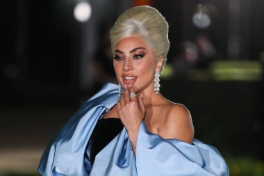 Şarkıcı Lady Gaga (Stefani Joanne Angelina Germanotta) özel bir Schiaparelli elbisesi ve Chopard mücevheri giyerek 25 Eylül 2021 'de Los Ang' daki Akademi Film Müzesi 'nin açılışındaki Akademi Müzesi' ne gelir.