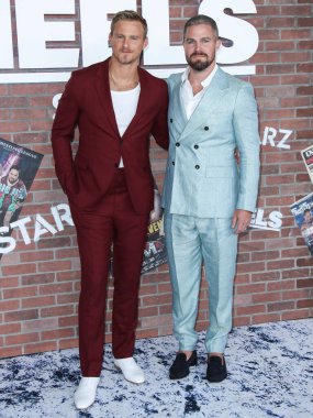 Aktörler Alexander Ludwig ve Stephen Amell (Scarosso ayakkabılarıyla Giorgio Armani takım elbise giyen), 10 Ağustos 2021 'de Los Angeles, Kaliforniya, ABD' de bulunan Sacramento Caddesi 2137 numaradaki STARZ 'ın' Heels 'inin Los Angeles Premiere' ine geldiler.