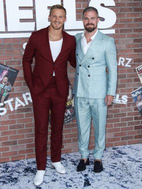 Aktörler Alexander Ludwig ve Stephen Amell (Scarosso ayakkabılarıyla Giorgio Armani takım elbise giyen), 10 Ağustos 2021 'de Los Angeles, Kaliforniya, ABD' de bulunan Sacramento Caddesi 2137 numaradaki STARZ 'ın' Heels 'inin Los Angeles Premiere' ine geldiler.
