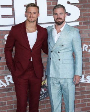 Aktörler Alexander Ludwig ve Stephen Amell (Scarosso ayakkabılarıyla Giorgio Armani takım elbise giyen), 10 Ağustos 2021 'de Los Angeles, Kaliforniya, ABD' de bulunan Sacramento Caddesi 2137 numaradaki STARZ 'ın' Heels 'inin Los Angeles Premiere' ine geldiler.