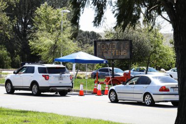26 Mart 2020 'de Pacoima, Los Angeles, Kaliforniya' da Hansen Baraj Parkı 'ndaki Coronavirus COVID-19 test merkezinin girişine giden arabalar kuyruktadır. ABD 'nin en kalabalık eyaleti olan Kaliforniya, salgın sırasında en çok etkilenenlerden biri oldu.. 