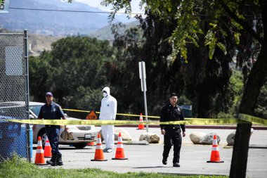 Tıbbi personel 26 Mart 2020 'de Pacoima, Los Angeles, Kaliforniya, ABD' deki Hansen Baraj Parkı 'ndaki Coronavirus COVID-19 test merkezindeki araçlarla ilgileniyor..
