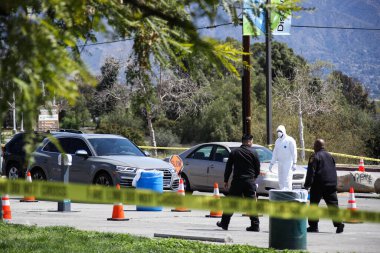 Tıbbi personel 26 Mart 2020 'de Pacoima, Los Angeles, Kaliforniya, ABD' deki Hansen Baraj Parkı 'ndaki Coronavirus COVID-19 test merkezindeki araçlarla ilgileniyor..