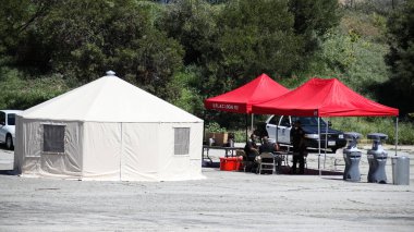 26 Mart 2020 'de Elysian Park, Los Angeles, Kaliforniya, ABD' de 1700 Stadyum Yolu 'ndaki Frank Hotchkin Memorial Eğitim Merkezi' ndeki Coronavirus COVID-19 test sahasında oturan personel