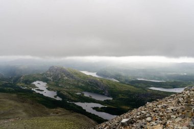 Rain cloud and view on lakes from Gaustatoppen mountain peak in Norway