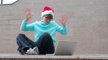 Noel Baba şapkalı kadın blogcu açık havada yayın yapıyor ve olaylar hakkında konuşuyor..