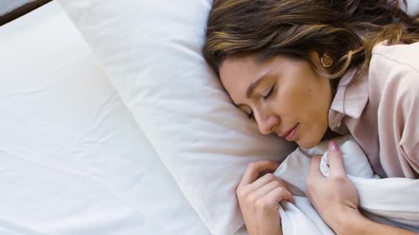 女性のトップビューは、毛布をまっすぐに彼女の睡眠中に笑顔と甘い眠り. — ストック動画