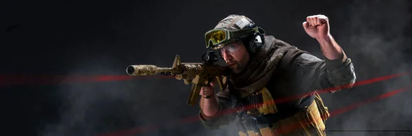 Professional special forces fighter, during a special operation is shrouded, in smoke against a dark background - he gives a stop signal, raising a clenched fist. Photo format 3x1. — Stock Photo, Image