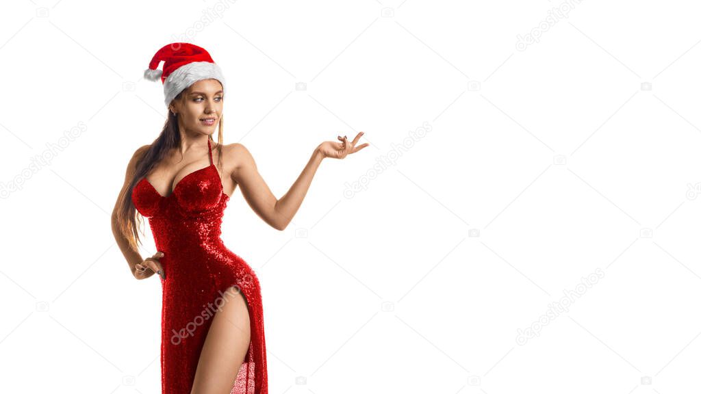 Stylish brunette woman in red dress and Santa hat showing on your product isolated on white background. Format photo 16x9.
