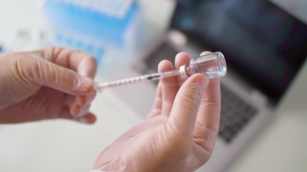 Ovanifrån av en läkare händer i handskar. Han drar in vaccinet i en spruta. — Stockvideo