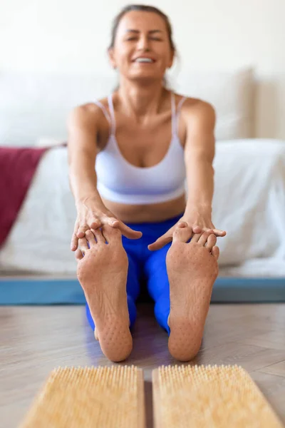 Jonge vrouw na op sadhu board te hebben gestaan. Sadhu voetenbord. Yoga ontspanningstraining. Focus op voeten. — Stockfoto