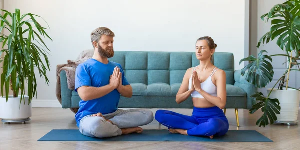 Ev içinde meditasyon yapan yaşlı bir çiftin fotoğrafı. Yoga pratiği. Biçim fotoğrafı 2x1. — Stok fotoğraf